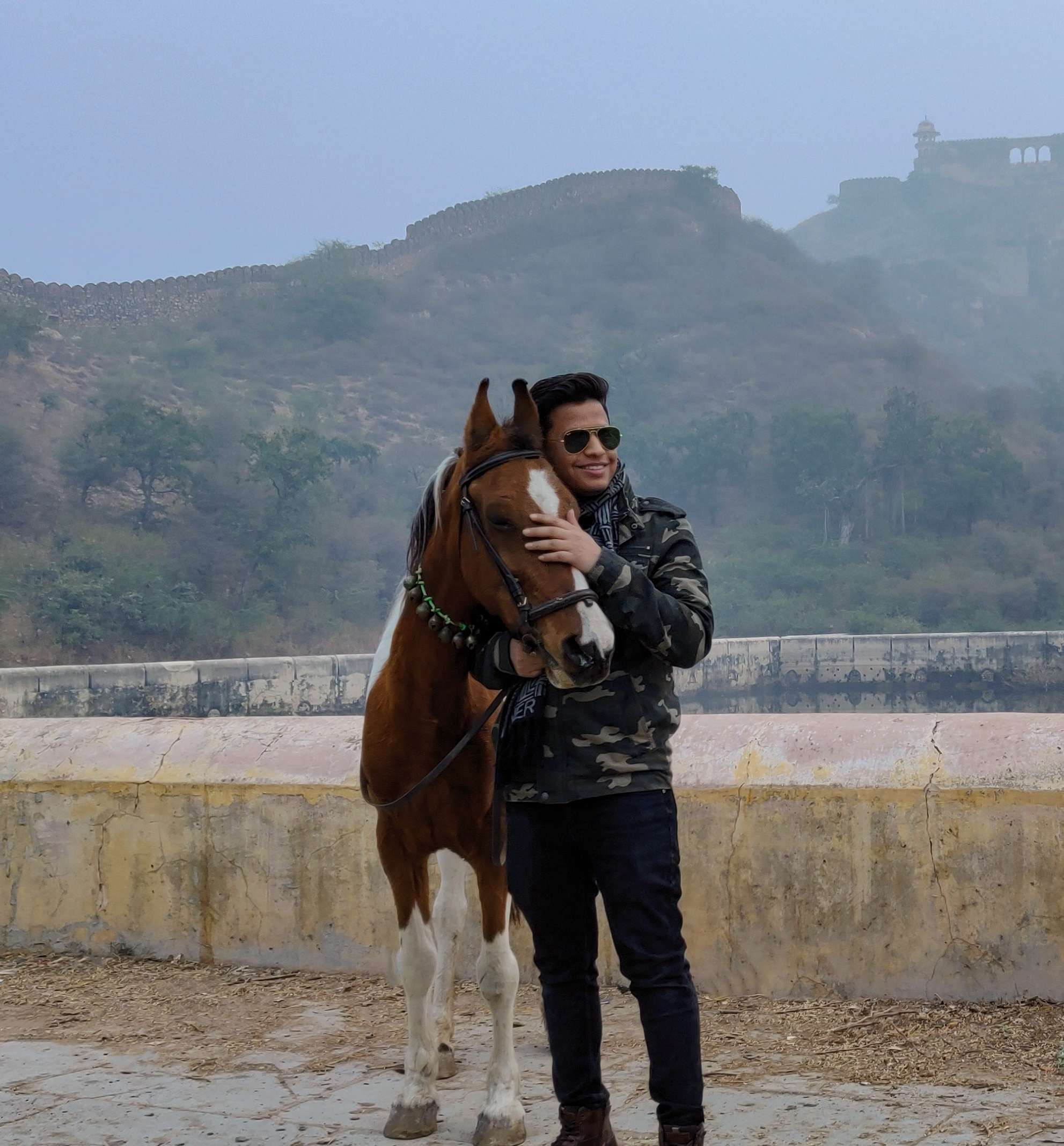 Devendra Singh Rathore, founder of India in Lens, sharing a moment with a horse at Amer Fort in Jaipur, reflecting Rajasthan’s heritage and historic landscape.