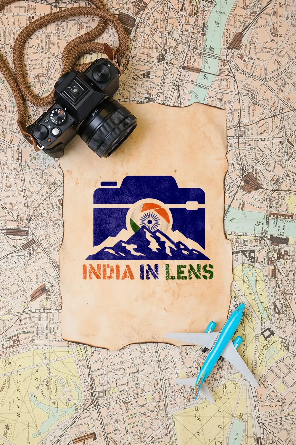 A parchment with the India in Lens logo resting on an old India map, with a DSLR camera and a small airplane, symbolising slow travel, photography, and discovering lesser known places.
