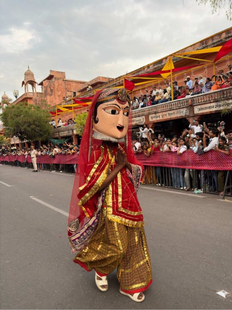 Traditional Rajasthani puppet performer walking through Jaipur during the Teej Festival procession